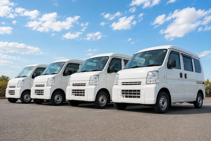 駐車場に並ぶ軽貨物バン